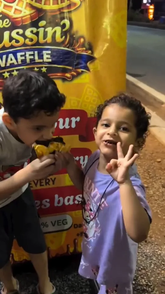 Two young customers eating waffles at the stall