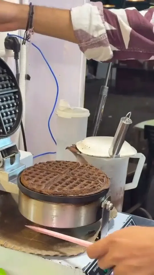 Batter spread across the iron and pressed into a waffle