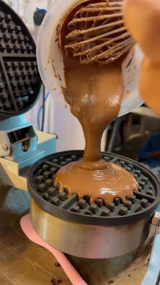 Chocolate batter poured onto the hot waffle iron